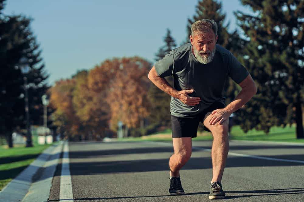 Older bearded man looking exhausted during an outdoor run